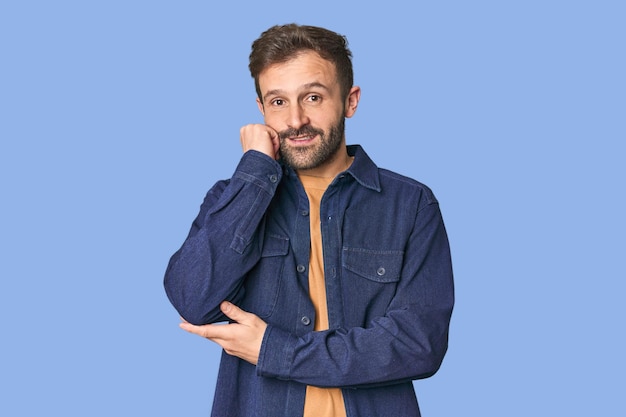 Studio portrait of young Hispanic male who feels sad and pensive looking at copy space