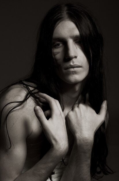 Studio portrait of a young man with paint on his face and bandage on his body