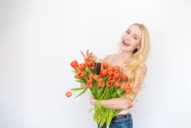 Studio portret prachtige blonde vrouw met lang golvend haar boeket rood houden