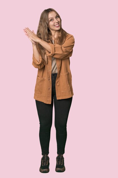 Foto studio portret van een blonde blanke vrouw die zich energiek en comfortabel voelt bij het wrijven van handen