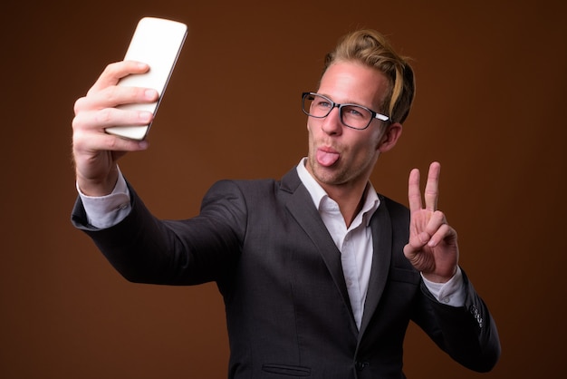 Studio portret van jonge knappe zakenman selfie te nemen