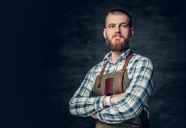 Studio portret van roodharige bebaarde man gekleed in afleece shirt over grijze achtergrond.