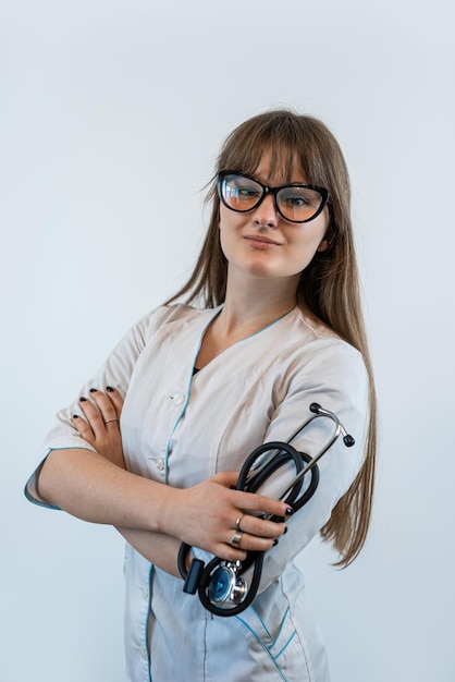 Studio shoot female doctor wearing medical coat and stethoscope isolated on white grey background