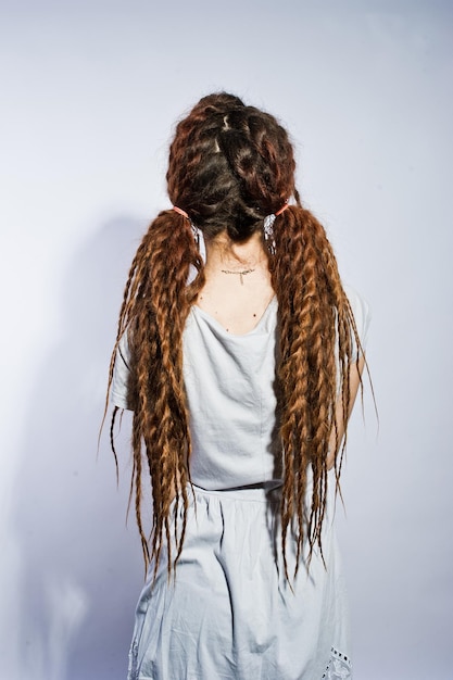 Studio shoot rug van meisje in grijze jurk met dreadlocks vlechten op witte achtergrond