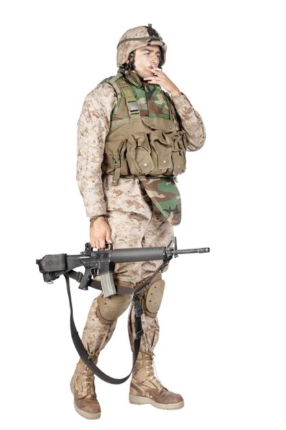Studio shoot van leger, marine machine gunner in camouflage gevechtsuniform en kogelvrije vesten, staande met machinegeweer, geïsoleerd op wit