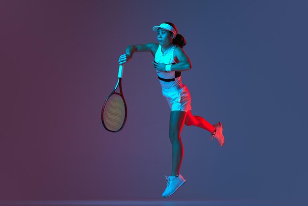 Foto colpo dello studio dell'addestramento attivo del giocatore di tennis professionista con la racchetta da tennis sopra il gradiente