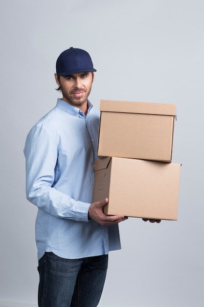 Studio shot of African delivery man carrying boxes