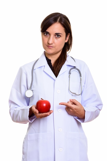 Studio shot of angry doctor pointing at red apple