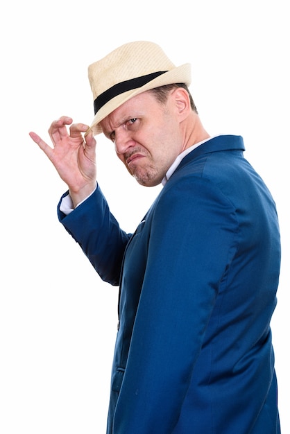 Studio shot of angry mature businessman holding hat