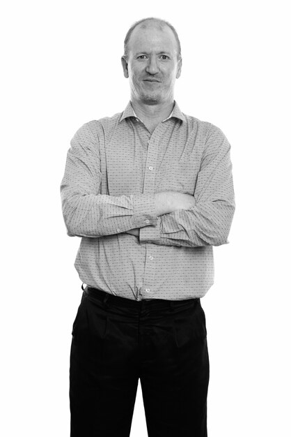 Studio shot of bald businessman with beard stubble isolated against white background in black and white