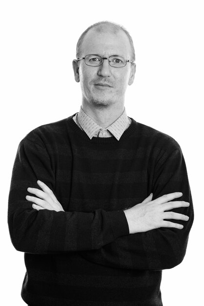 Studio shot of bald man with beard stubble isolated against white background in black and white