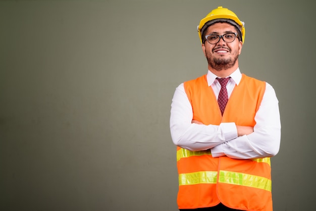 Studio shot of bearded man construction worker against colored