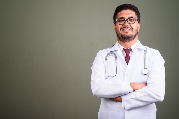 Studio shot of bearded man doctor against colored