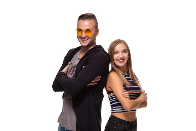 Studio shot of beautiful young couple standing back to back and looking at the camera