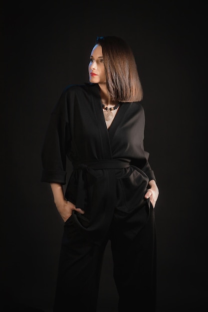 Studio shot of brunette woman 30s wearing black silk pajamas