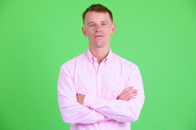 Studio shot of businessman wearing pink shirt against green background