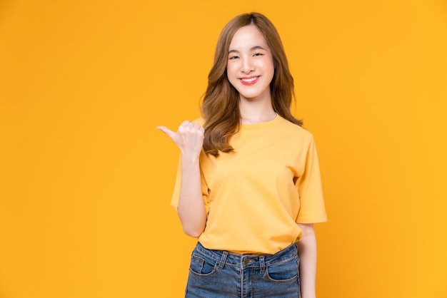 Photo studio shot of cheerful beautiful asian woman stand on yellow background