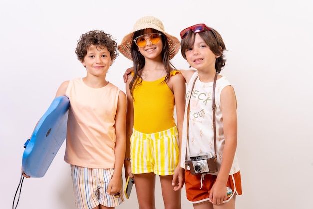 Студийный снимок детей, улыбающихся на летних каникулах на белом фоне