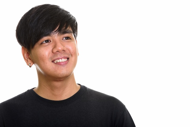 Studio shot of cool happy Asian man smiling and thinking