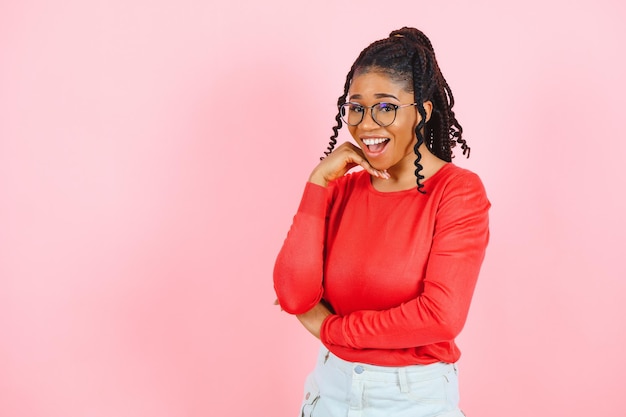 Studio shot of glad charming young female with Afro haircut isolated over pink background with blank space for your promotional content Pleasant emotions