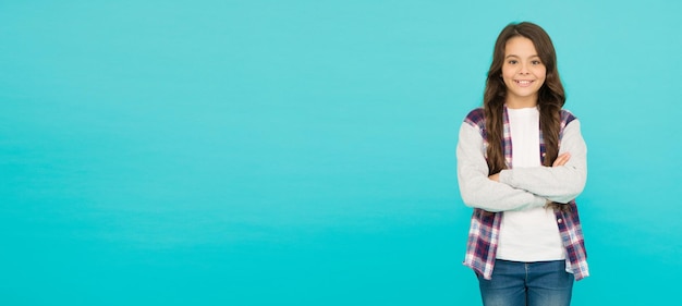 Photo studio shot of glad child childhood happiness pleasant emotions stylish teen girl turquoise background pretty teen girl with long hair kid fashion advertising back to school copy space