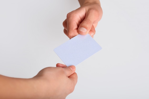 Studio shot of hand giving blank plastic card