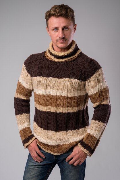 겨울을위한 준비 터틀넥 스웨터를 입고 잘 생긴 수염 난된 남자의 스튜디오 샷