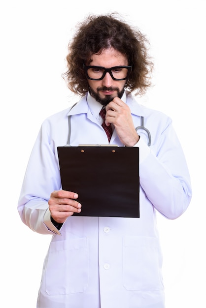 Studio shot of handsome man doctor reading on clipboard