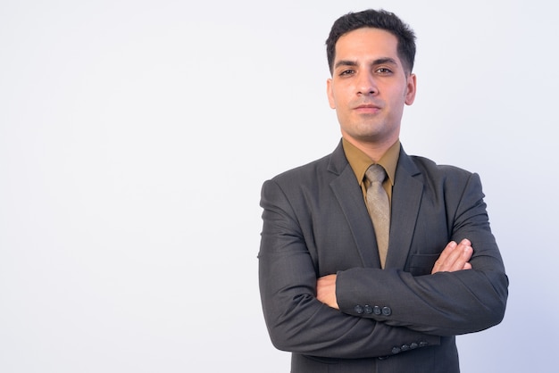 Studio shot of handsome Persian businessman in suit isolated against white