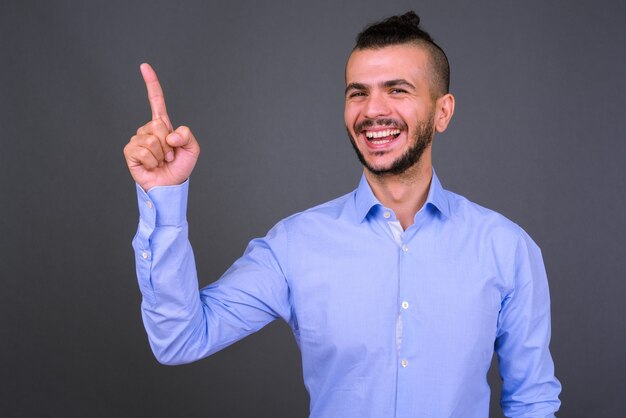 Studio shot of handsome Turkish businessman against gray background