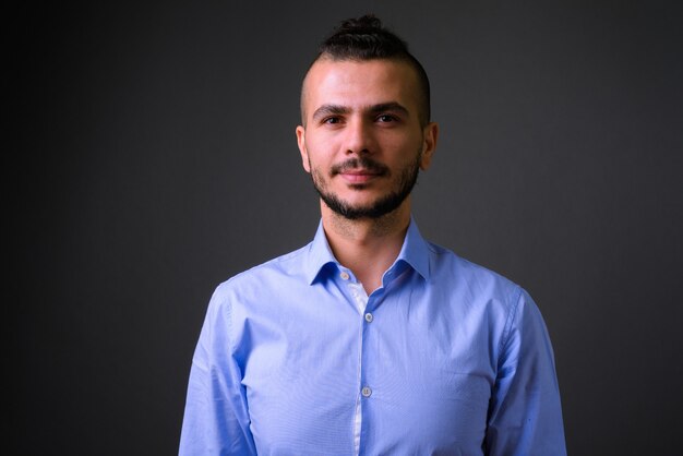 Studio shot of handsome Turkish businessman against gray background