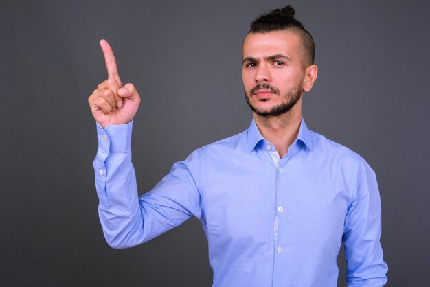 Foto studio shot di bel imprenditore turco su sfondo grigio