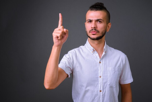 Studio shot of handsome Turkish man against gray background