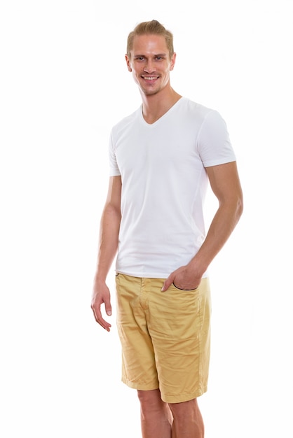 Studio shot of happy young handsome man smiling while standing