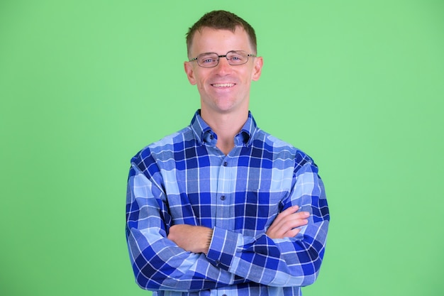 Studio shot of hipster man wearing eyeglasses against green background