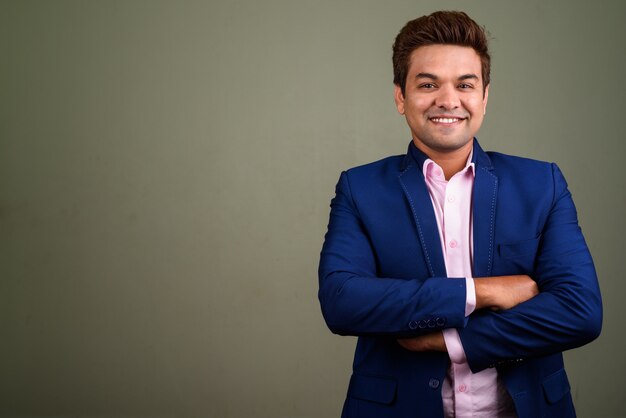 Studio shot of Indian businessman wearing suit against colored background