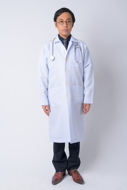 Studio shot of Japanese man doctor against white background