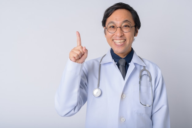 Studio shot di uomo giapponese medico contro uno sfondo bianco