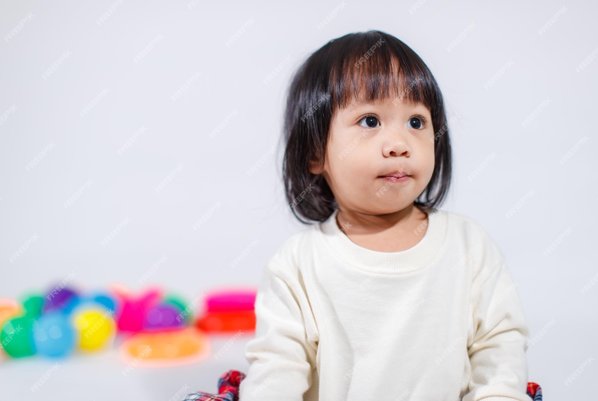 Premium Photo | Studio shot of little cute short black hair asian baby girl daughter model in casual plaid skirt sitting on floor smiling laughing playing with colorful round balls toy alone Premium Photo | Studio shot of little cute short black hair asian baby girl daughter model in casual plaid skirt sitting on floor smiling laughing playing with colorful round balls toy alone
