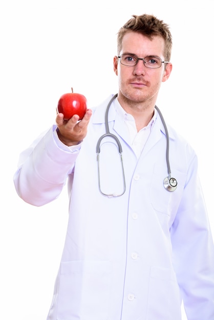 Studio shot of man doctor holding red apple