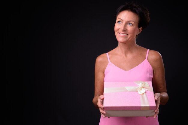 Studio shot of mature beautiful Scandinavian woman with short hair against black background