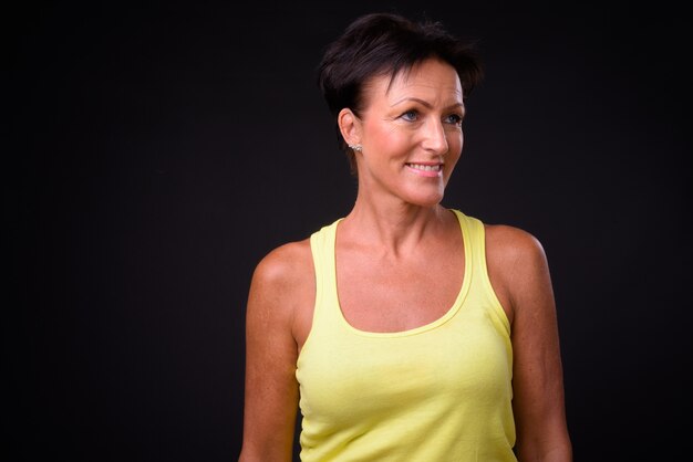 Studio shot of mature beautiful Scandinavian woman with short hair against black background