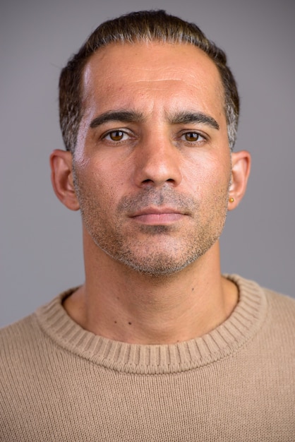 Studio shot of mature handsome Persian man isolated against white background