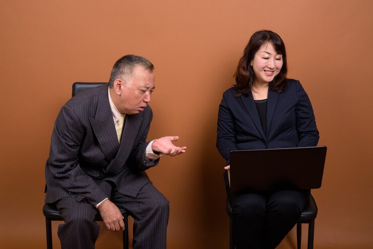 Photo 成熟的日本商人和成熟的日本女商人一起在棕色的背景下拍摄
