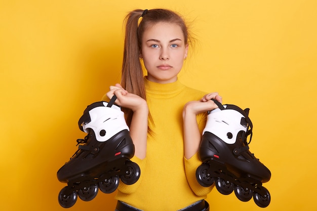 Studio shot of sad woman posing isolated over yellow