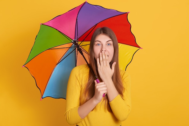 Studio shot of shocked woman looking directly at camera