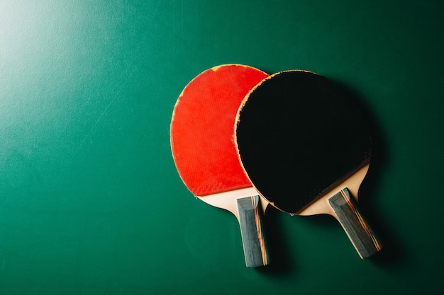 Foto studio shot di due racchette da ping pong sono sul tavolo da gioco verde