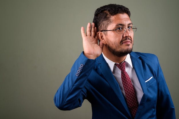 Foto studio shot van bebaarde zakenman pak dragen tegen gekleurd