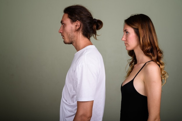 Studio shot van de jonge knappe man en jonge mooie vrouw samen tegen een gekleurde achtergrond