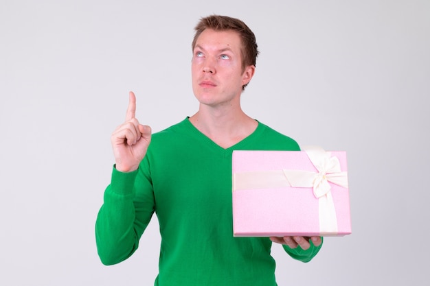 Studio shot van de jonge knappe man klaar voor Valentijnsdag tegen witte achtergrond